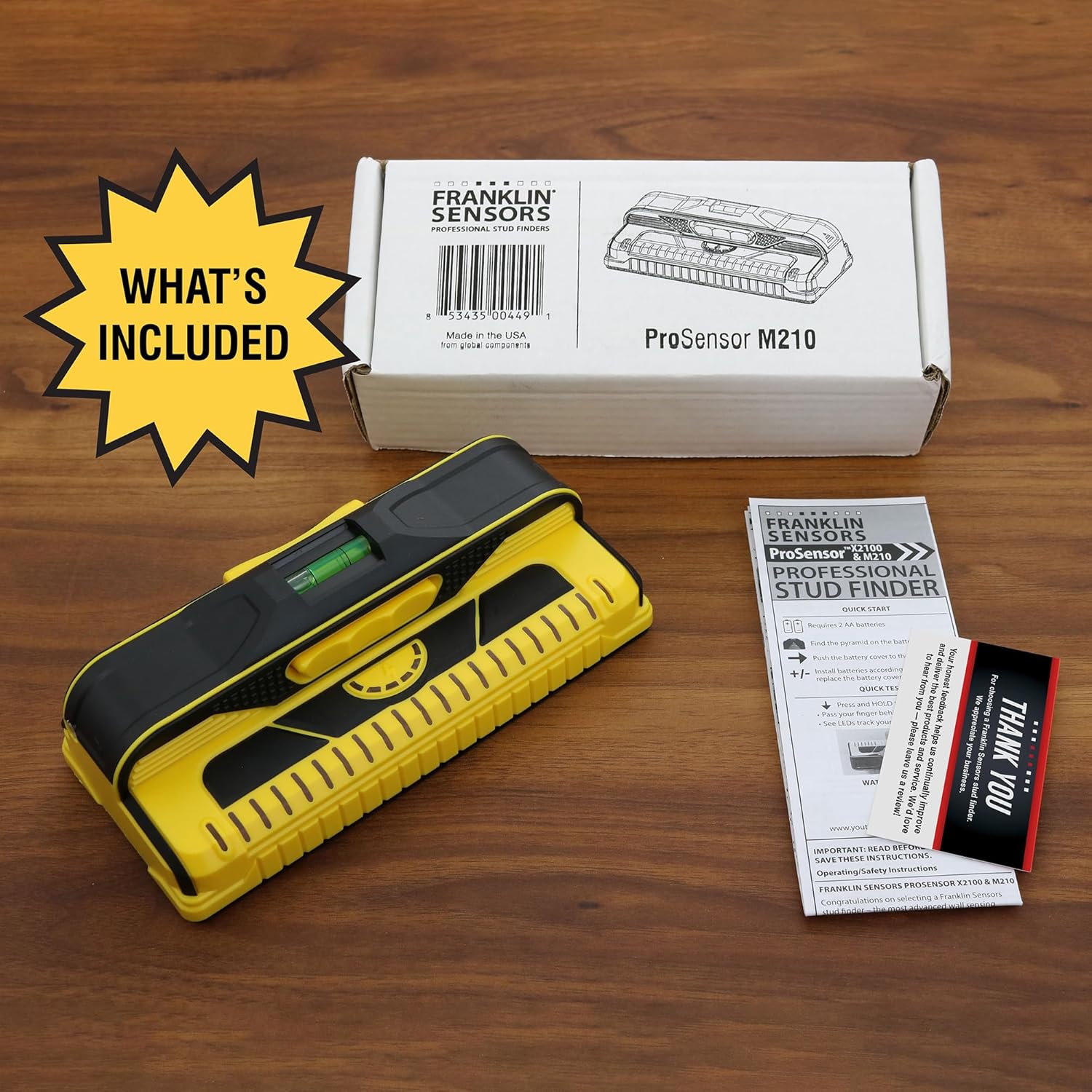 Yellow stud finder with Franklin Sensors ProSensor M210 packaging on a wooden surface